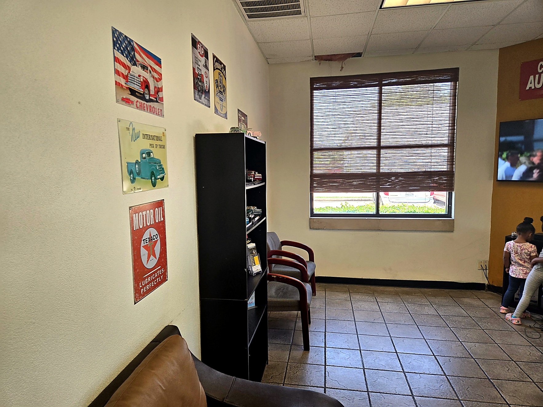 Waiting room with vintage automotive wall signs at Auto Care USA Briar Forest