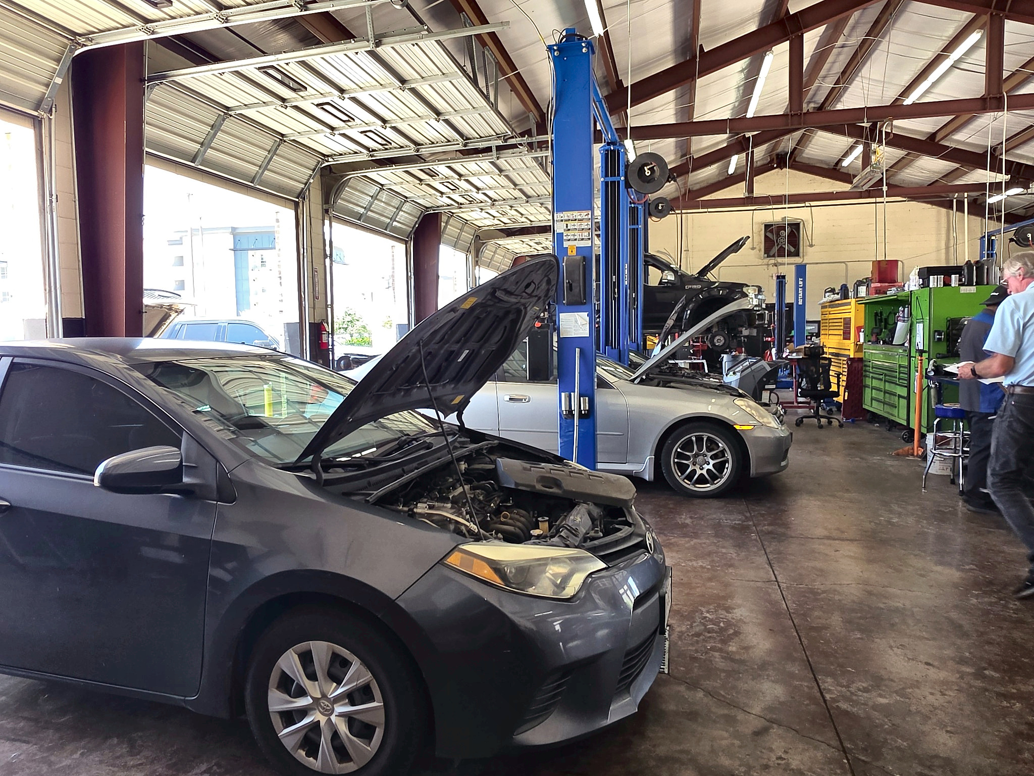 Automotive repair bays with vehicles on lifts at Auto Care USA in Katy, TX